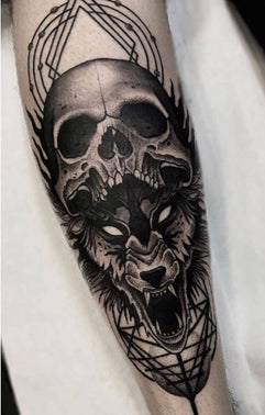 A forearm tattoo of a haunting growling wolf underneath a human skull with geometric designs in the background